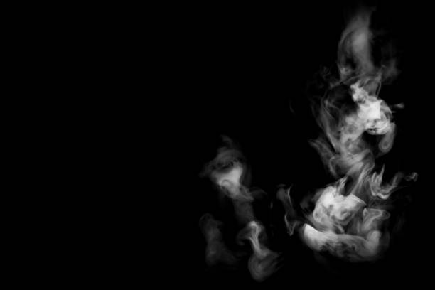 istock A single puff of smoke on a completely black background. Selective focus, lots of copy space on the left of the frame. 1487055849