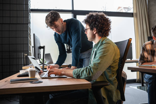 istock Two engineers and programmers sitting in the office and working on a new startup project. Discuss business strategy. 1487056827