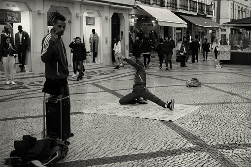 Lisbon, Porutgal - January 15, 2023: A young woman performs hip-hop dancing at the Rua Augusta street in Lisbon downtown.