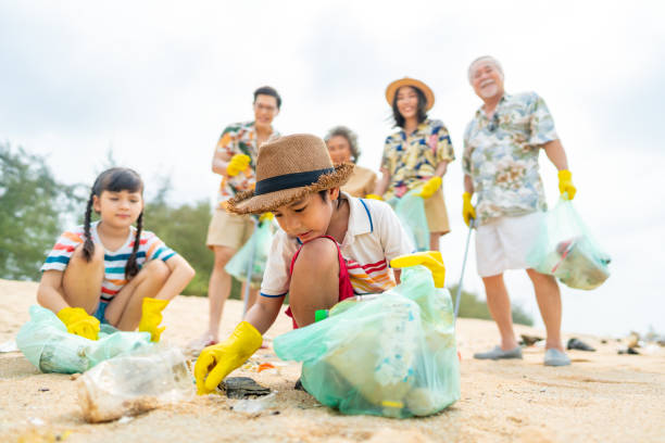 istock Group of multi-Generation Asian family picking up garbage on the beach. 1487059084