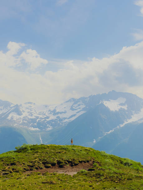 woman in distance hiking with background view of scenic sunnmore alps in norway - layered mountain peak summer light imagens e fotografias de stock