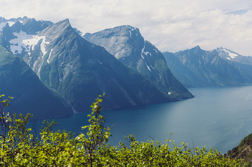 High-angle photo of majestic fjord surrounded by beautiful snowcapped mountain peaks in Western Norway, Scandinavia