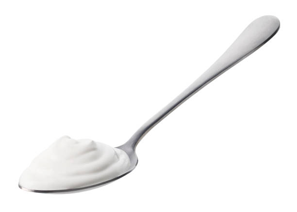 istock Spoon of fresh greek yogurt on white background 1487060292