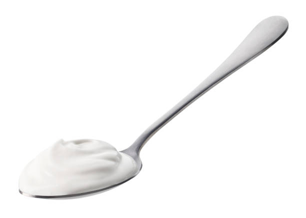 istock Spoon of fresh greek yogurt on white background 1487060293