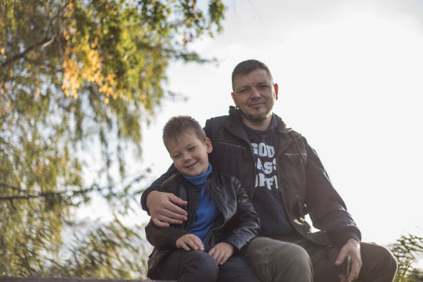 istock Father hugging his son outdoors on the bench. Precious moments between Dad  and son 1487060475
