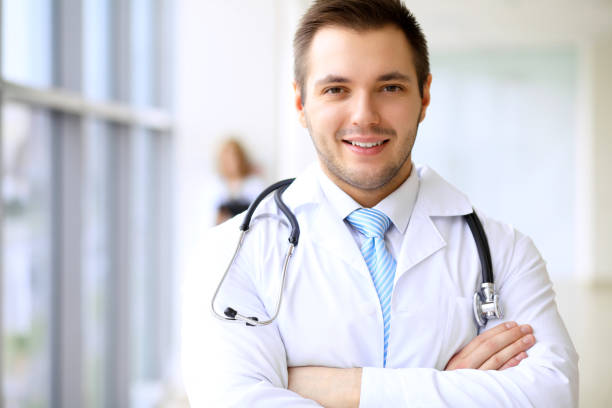 istock Smiling doctor waiting for his team while standing upright 1487061879