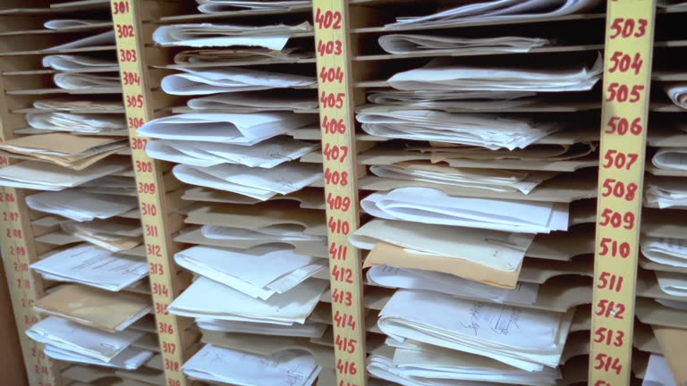 Many paper documents are in numbered cells.