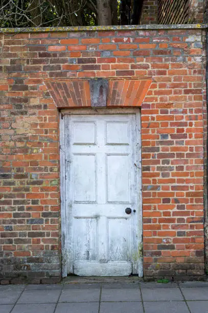 Old white door in brick wall
