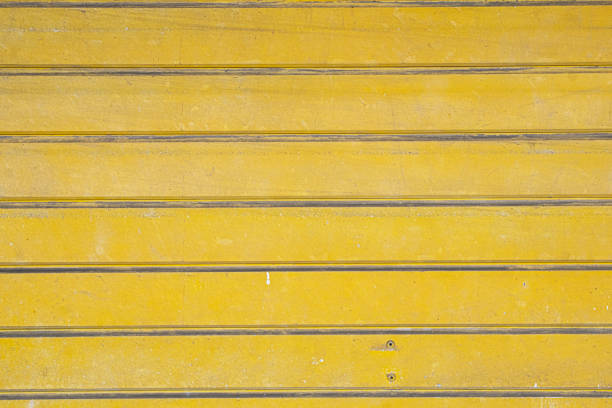 Dirty yellow aluminum corrugated door background texture