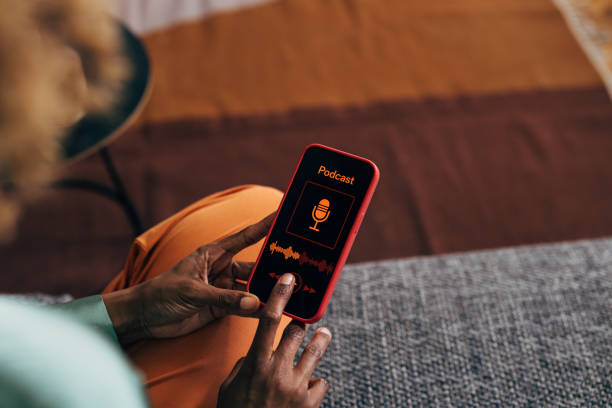 una mujer irreconocible usando su teléfono móvil - orange white audio fotografías e imágenes de stock