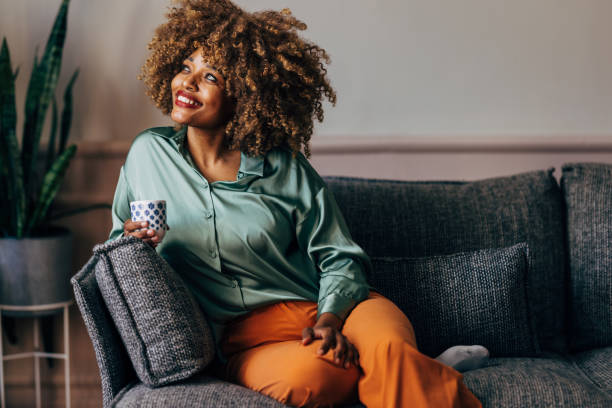 istock A Happy Beautiful Woman Looking Away While Relaxing At Home Drinking Coffee 1487069585
