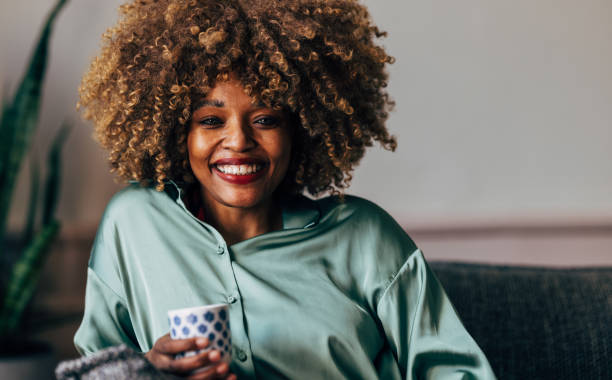 A Happy Beautiful Woman Looking At Camera While Relaxing At Home