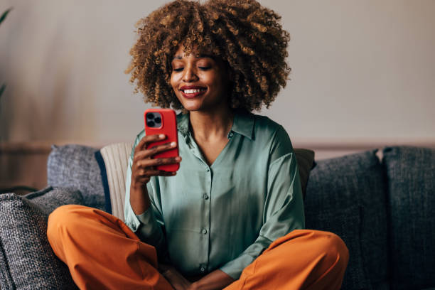 istock A Happy Beautiful Woman Texting On Her Mobile Phone While Relaxing At Home 1487069594