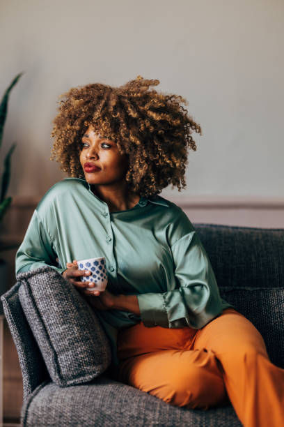 istock A Happy Beautiful Woman Looking Away While Relaxing At Home Drinking Coffee 1487069619