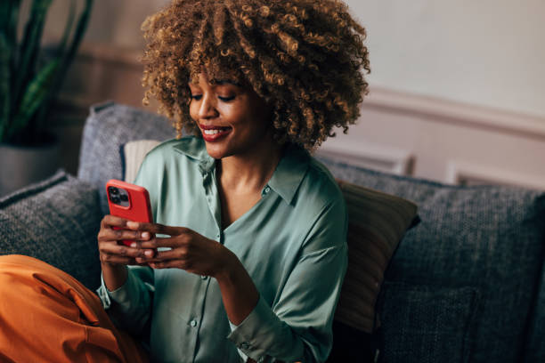 istock A Happy Beautiful Woman Texting On Her Mobile Phone While Relaxing At Home 1487069629