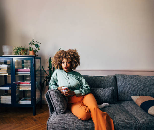 istock A Beautiful Woman Looking At Camera While Relaxing At Home Drink 1487069651