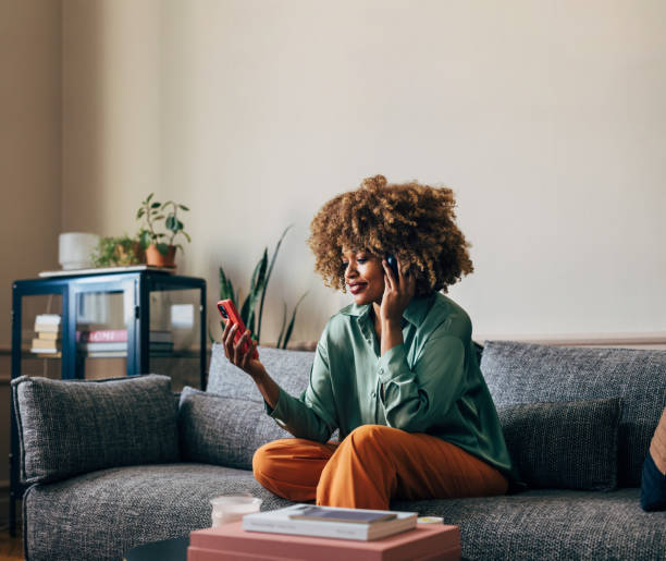 istock A Happy Beautiful Woman Using Her Headphones While Watching Some 1487069652