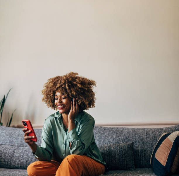 istock A Happy Beautiful Woman Using Her Headphones While Watching Some 1487069666