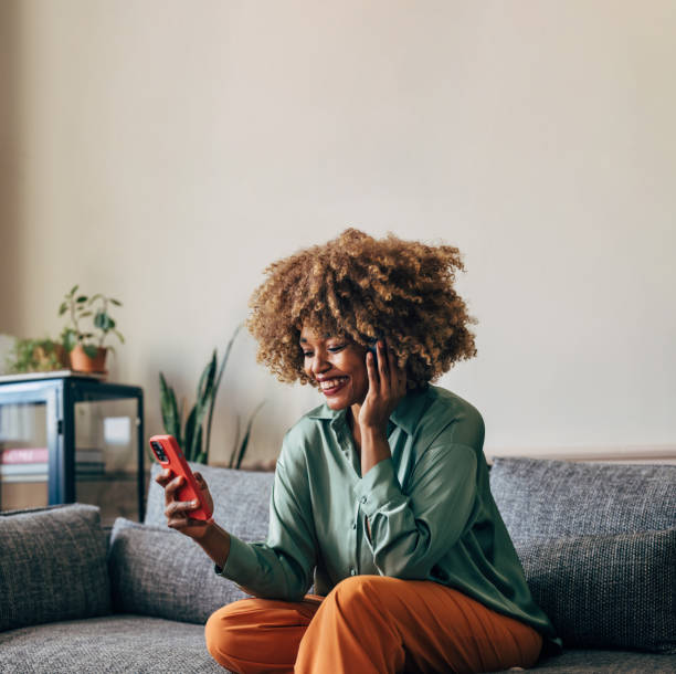 istock A Happy Beautiful Woman Using Her Headphones While Watching Some 1487069731