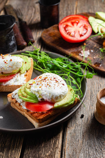istock Toast with poached egg, tomatoes and avocado. Healthy breakfast 1487072801