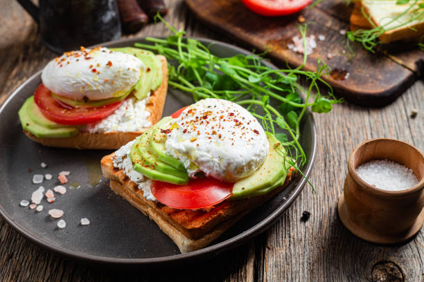 istock Toast with poached egg, tomatoes and avocado. Healthy breakfast 1487072856