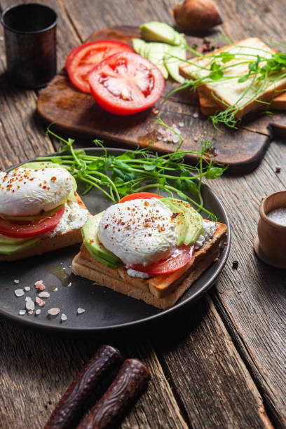 istock Toast with poached egg, tomatoes and avocado. Healthy breakfast 1487073059