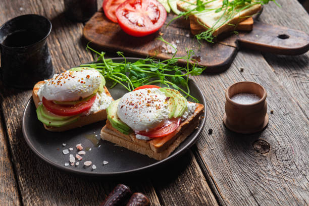 istock Toast with poached egg, tomatoes and avocado. Healthy breakfast 1487073106