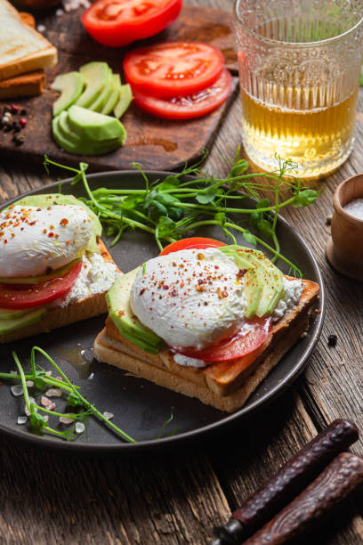 istock Toast with poached egg, tomatoes and avocado. Healthy breakfast 1487073179