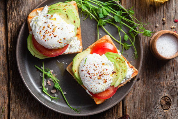 istock Toast with poached egg, tomatoes and avocado. Healthy breakfast 1487073203