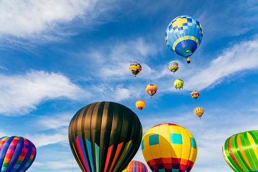 Colorful hot air balloons flying in the blue sky with white clouds