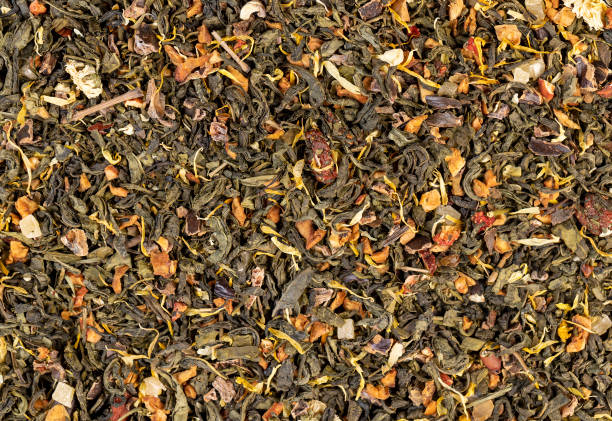 una grande quantità di tè verde secco con pezzi di frutta - tea jasmine tea green black foto e immagini stock