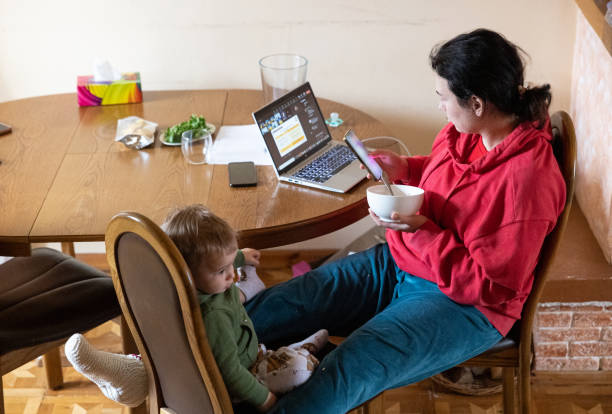 istock The mother feeds her son while working from her home. 1487074196