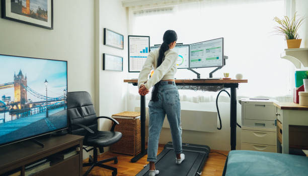 istock Woman at home office is walking on under desk treadmill 1487078177