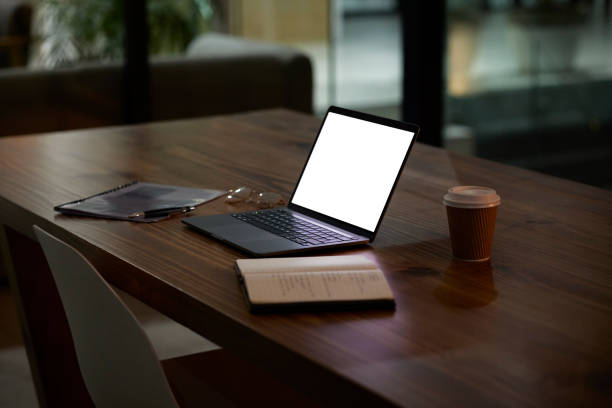 istock Night, work and mockup laptop on a table for business, late shift and organized workspace. Planning, corporate and blank computer screen for marketing on a desk for a deadline or overtime in the dark 1487079876