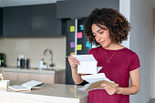 Woman at home reading a letter in the mail
