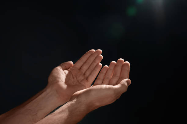 istock Man reaching hands to light in darkness, closeup 1487081288