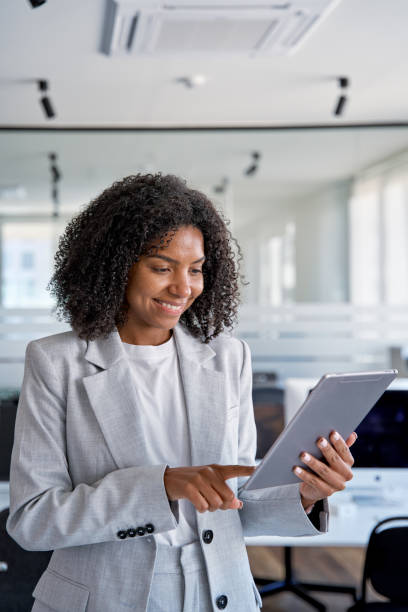 istock Vertical portrait of young user business woman using touchscreen pc tablet. 1487082344