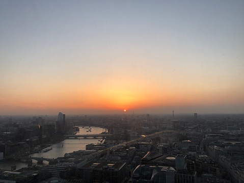 Sun setting over Thames river and cityscape