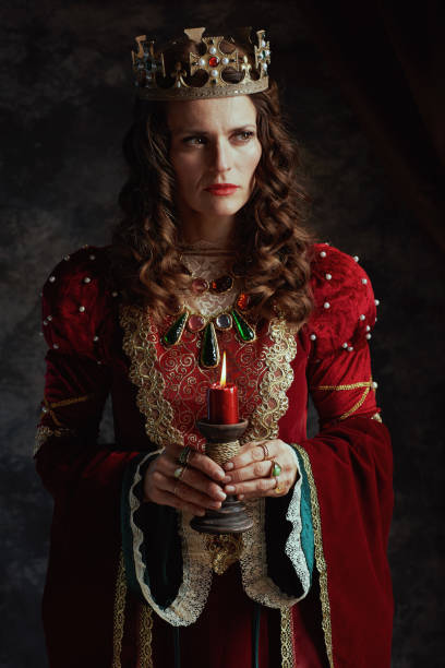 istock medieval queen in red dress with candle and crown 1487084892
