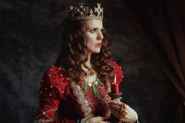istock medieval queen in red dress with candle and crown 1487084895