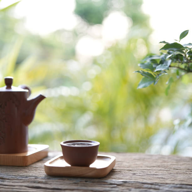 istock traditional tea pot and tea cup on wooden table outdoor greenery view 1487085040