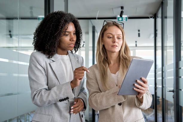 istock Two businesswoman working together using digital tablet pc at modern office. 1487085920