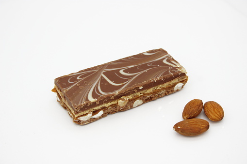 Chocolate bars with almonds on a white background. Shallow dof.