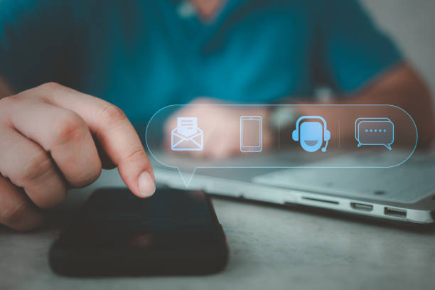 istock Customer support hotline. Man using smar phone with the email, call phone, address and chat message icons. 1487086452