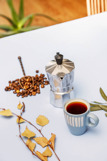 istock Coffee still life with dry tree leaves and ingredients, a small coffee pot and beans with a spoon 1487086461