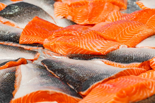 istock Salmon fillet raw cut into chunks, chilled, at fish market, selective focus 1487089390