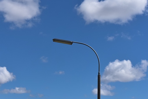A street lamp stands in contrast against a bright blue sky, giving a tranquil and peaceful atmosphere to the scene