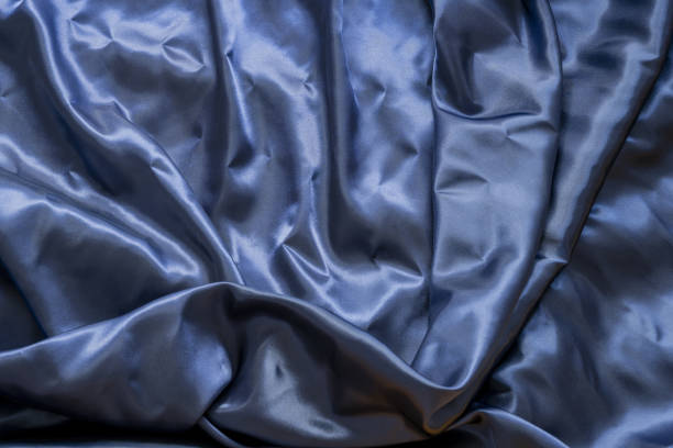 istock indigo blue satin fabric background with water and wrinkles 1487089757