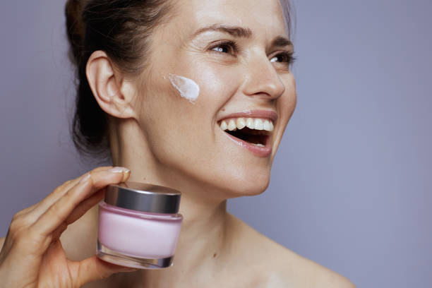 istock smiling modern woman with cosmetic cream jar 1487095688