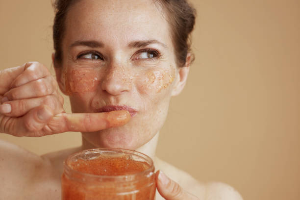istock smiling modern woman with face scrub against beige background 1487095708